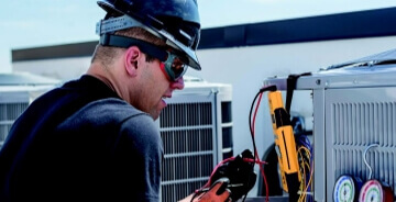 Hillcrest employee providing maintenance services on an AC unit